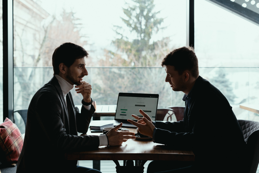 Small business office with owner and advisor discussing claims.